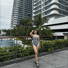 a woman in a bathing suit stands in front of a building
