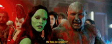 a man and a woman are standing next to each other in a crowd and the man is talking to the woman .