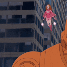 a woman in a pink superhero costume is flying over a building