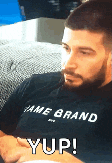 a man with a beard wearing a name brand shirt