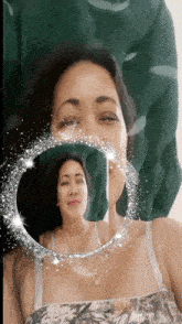 a woman is looking at herself in a mirror surrounded by glitter