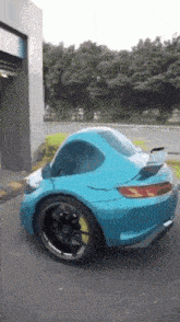 a blue sports car with a yellow tire is parked in front of a building