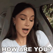 a woman is sitting in a car with her mouth open and says how are you