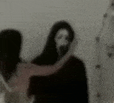 a blurry picture of a woman hugging a man with a mask on .