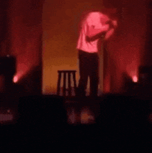 a man is standing on a stage holding a microphone and saying `` no , you 're not `` .