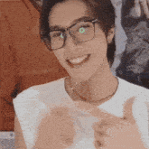 a man wearing glasses and a white shirt is smiling