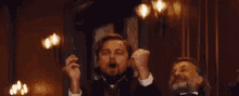 a man in a tuxedo is holding his arms in the air and says gif keyboard !