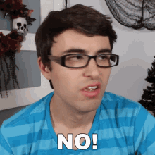 a man wearing glasses and a blue shirt has the word no on his chest