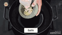 a person grinding garlic into a mortar and pestle