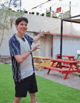 a man standing in front of red picnic tables with pixverse ai written on the bottom right