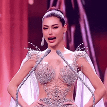 a woman in a very fancy dress is speaking into two microphones