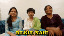 three women are sitting on a couch with the words bilkul nahi written on the bottom