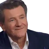 a man in a suit and white shirt smiles with his eyes closed