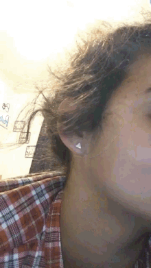 a close up of a woman 's ear with a sign on the wall that says daddy