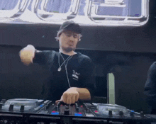 a man wearing a black t-shirt that says t on it is playing a dj set