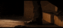 a close up of a person 's feet in a dark room wearing black shoes .