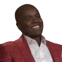 a man wearing a red jacket and a white shirt is smiling