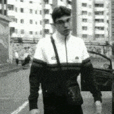 a black and white photo of a man wearing an ellesse sweatshirt