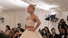 a woman in a white wedding dress is walking down a runway .