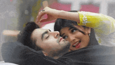 a woman is touching a man 's forehead while he sleeps