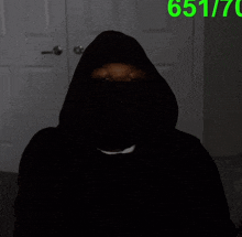 a man in a hooded sweatshirt is pointing at the camera with the number 651770 above him