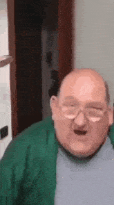 a bald man wearing glasses is making a funny face .