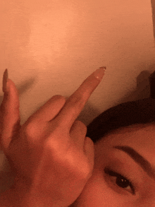 a close up of a woman 's face giving the middle finger