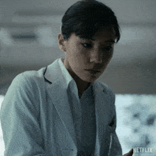 a woman in a white lab coat with netflix written on the bottom right