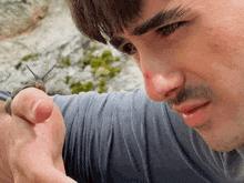 a man is holding a snail on his finger and looking at it