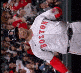 a boston baseball player stands in front of a crowd of people