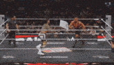 two men are wrestling in a wrestling ring and one of them is laying on the floor .