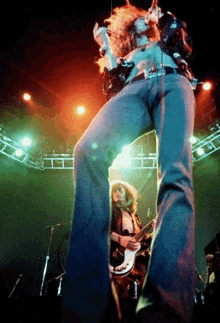 a man singing into a microphone while another man plays a guitar on a stage