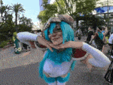a woman with blue hair and a white shirt is making a face with her hands