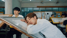 a man in a white shirt is laying on a table
