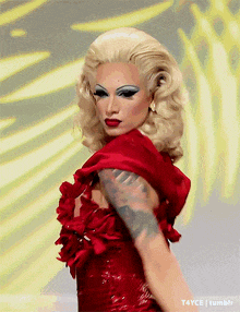 a woman in a red dress has a tattoo on her arm ..