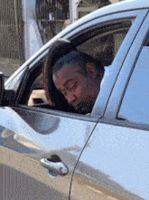 a man with a ponytail looks out of the window of a car
