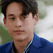 a close up of a man 's face wearing a blue suit and striped shirt