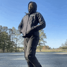 a man wearing a black jacket with a hood that says ' columbia ' on it