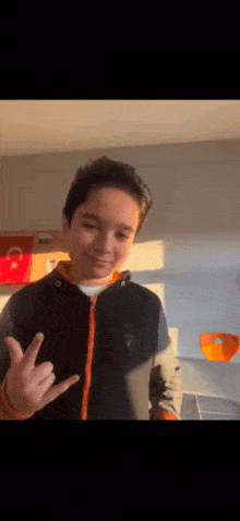 a young boy is making a peace sign with his hand