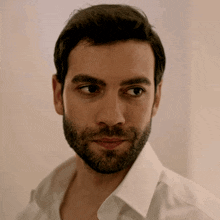 a man with a beard wears a white shirt