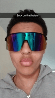 a person wearing sunglasses with the caption suck on that haters