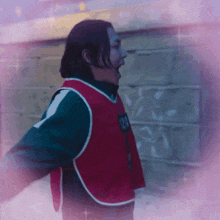 a man is wearing a red vest with the number 24 on it