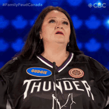 a woman is wearing a thunder jersey and speaking into a microphone