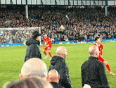 a soccer game is being played in front of a crowd and a man in a red shirt with the number 29 on it