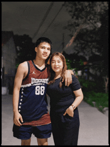 a man wearing a jersey with the number 88 on it poses for a picture with a woman
