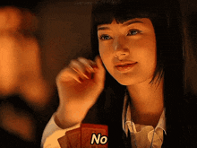 a woman holding a card with the word no on it