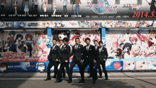 a group of men in suits are standing in front of a billboard that says 2014