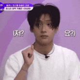 a young man in a white t-shirt is making a funny face while talking into a microphone ..