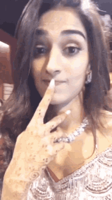 a woman is making a funny face with her finger to her mouth