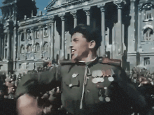 a man in a military uniform stands in front of a crowd